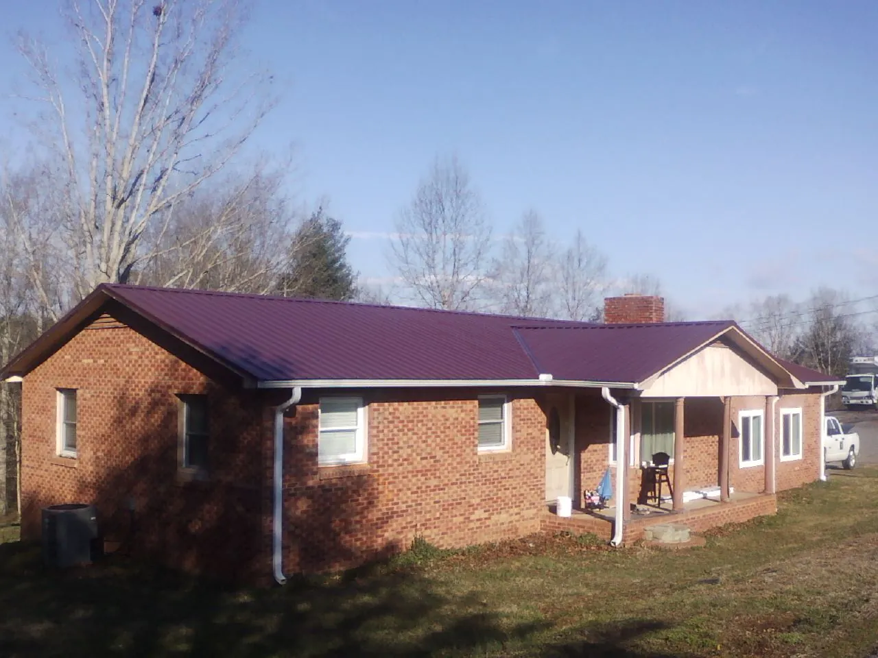 Burgundy metal roof on a brick ranch home with a new addition in Luray